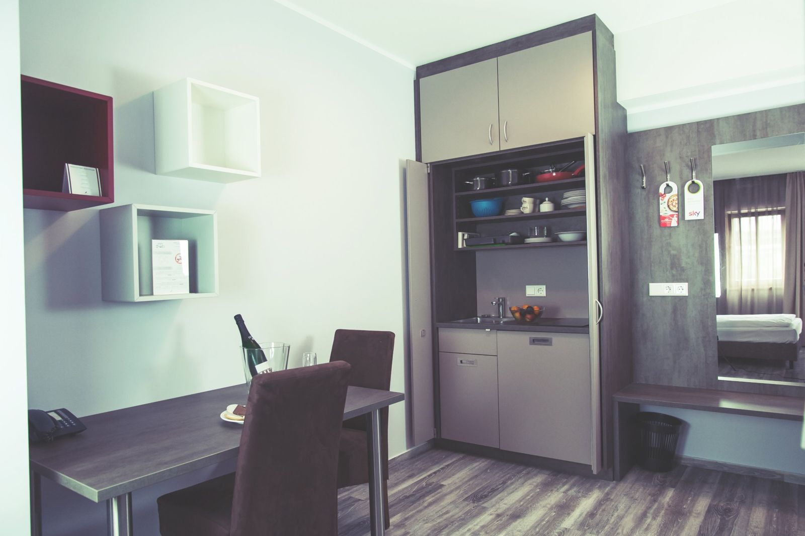 Aufgeräumtes Zimmer mit Schreibtisch und Kitchenette